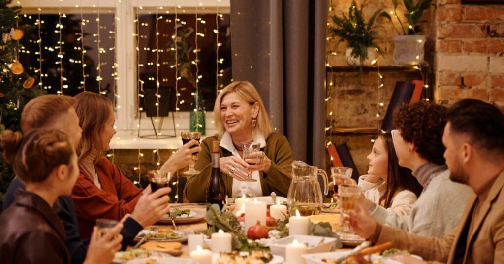 Люди за святково прикрашеним столом під час новорічного чи різдвяного застілля