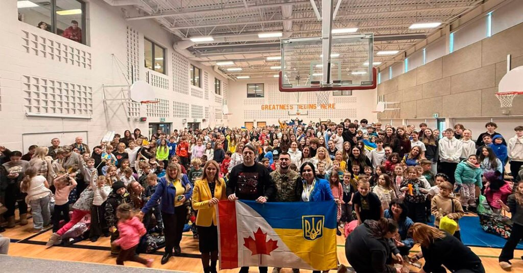 Спільне фото Сергія Притули, військового Ярмака та української громади Міссісаги з прапорами України та Канади.