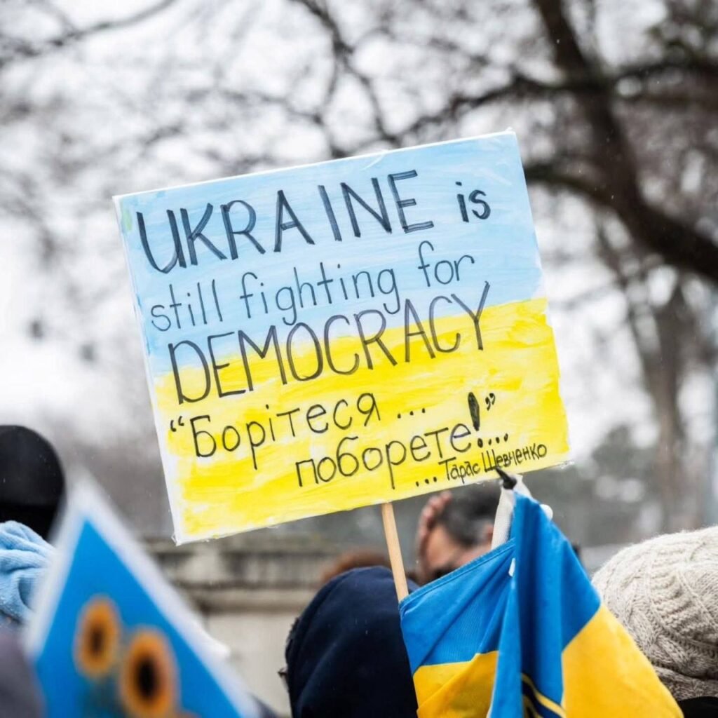 Плакат на підтримку України із написом про боротьбу за демократію та цитатою Тараса Шевченка