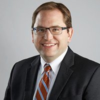 Ігор Михальчишин, виконавчий директор UCC National, у діловому костюмі та окулярах