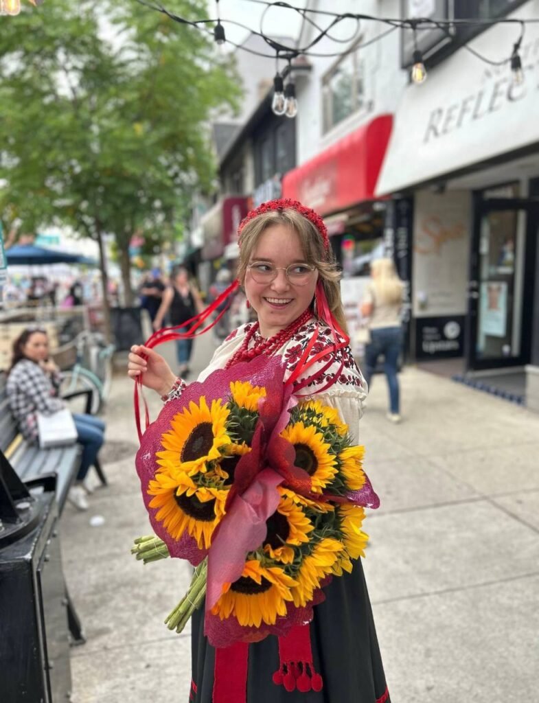 Софія Рочева в українському національному костюмі з букетом соняшників у Торонто