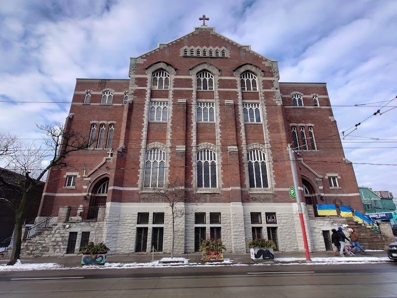 Фасад Української Католицької Церкви Святого Миколая в Торонто з українськими прапорами на вході