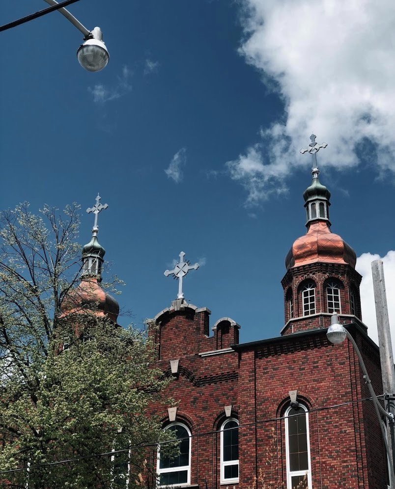 Фасад Української православної церкви святого Андрія в Торонто з червоної цегли та мідними куполами