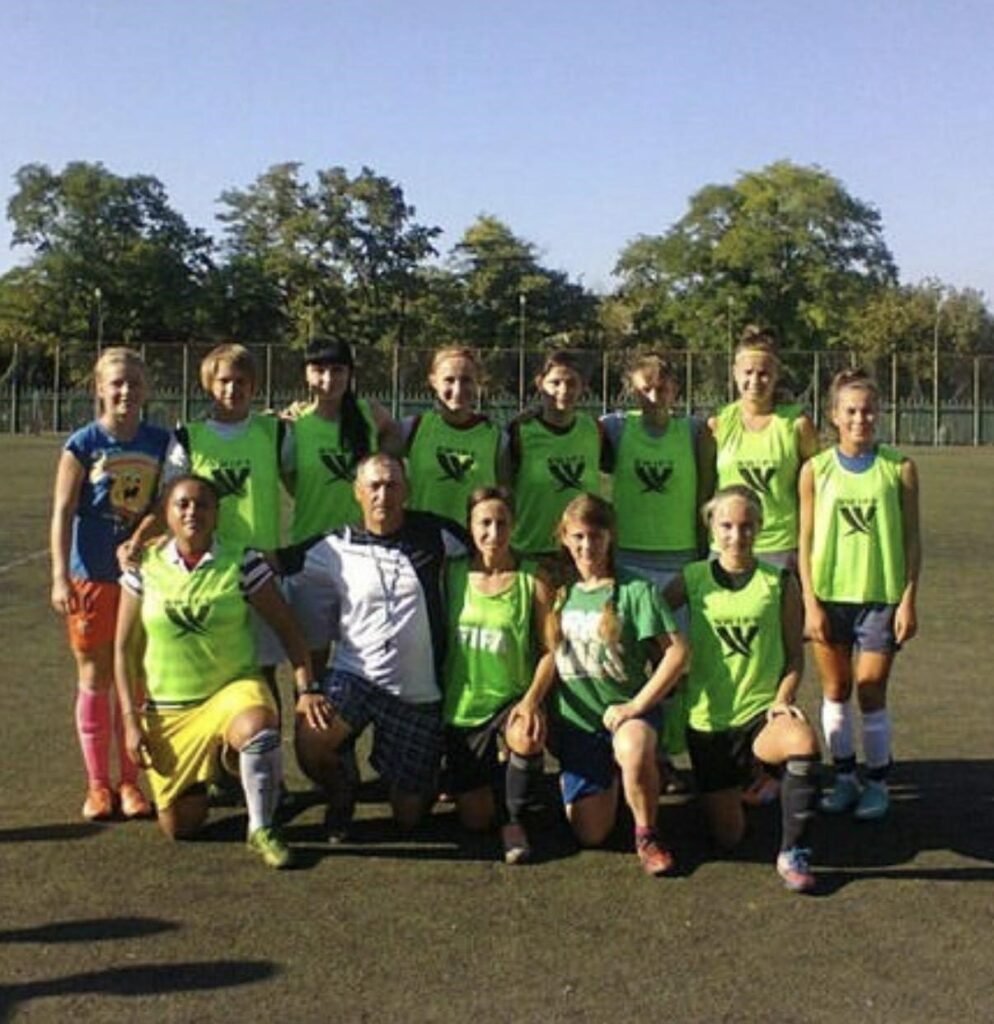 Альона Пархоменко у складі дівочої футбольної команди з тренером у Маріуполі