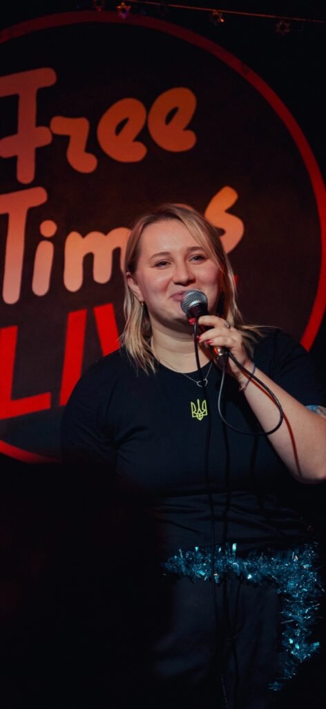 Комікеса Альона Пархоменко з Маріуполя виступає з мікрофоном на сцені UCrazy Stand Up у Канаді