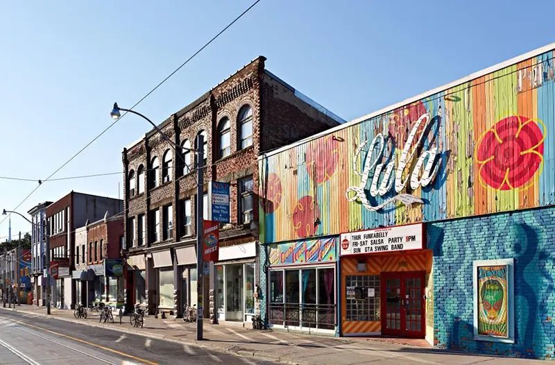 Яскравий фасад будинку з муралом та написом Lula Lounge на вулиці Dundas Street West у районі Маленька Португалія, Торонто.
