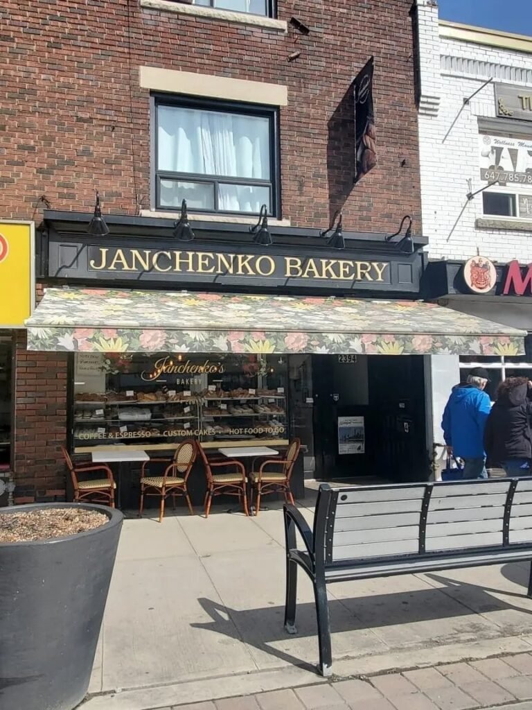 Фасад української пекарні Janchenko Bakery з квітковим навісом та столиками на вулиці в Торонто