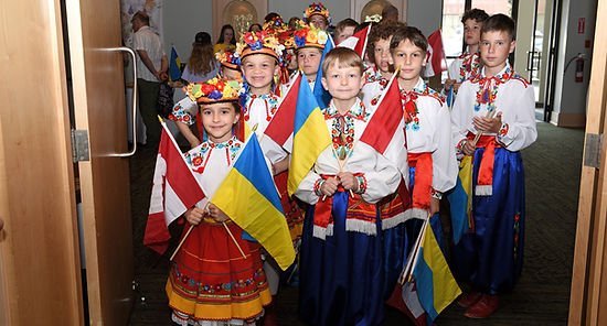 Група дітей в українському національному вбранні з прапорцями України та Канади в руках.