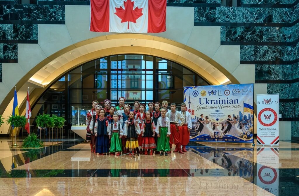 Дитячий фольклорний ансамбль Крила в традиційних українських костюмах стоїть перед банером Ukrainian Graduation Waltz у Міссісазі.