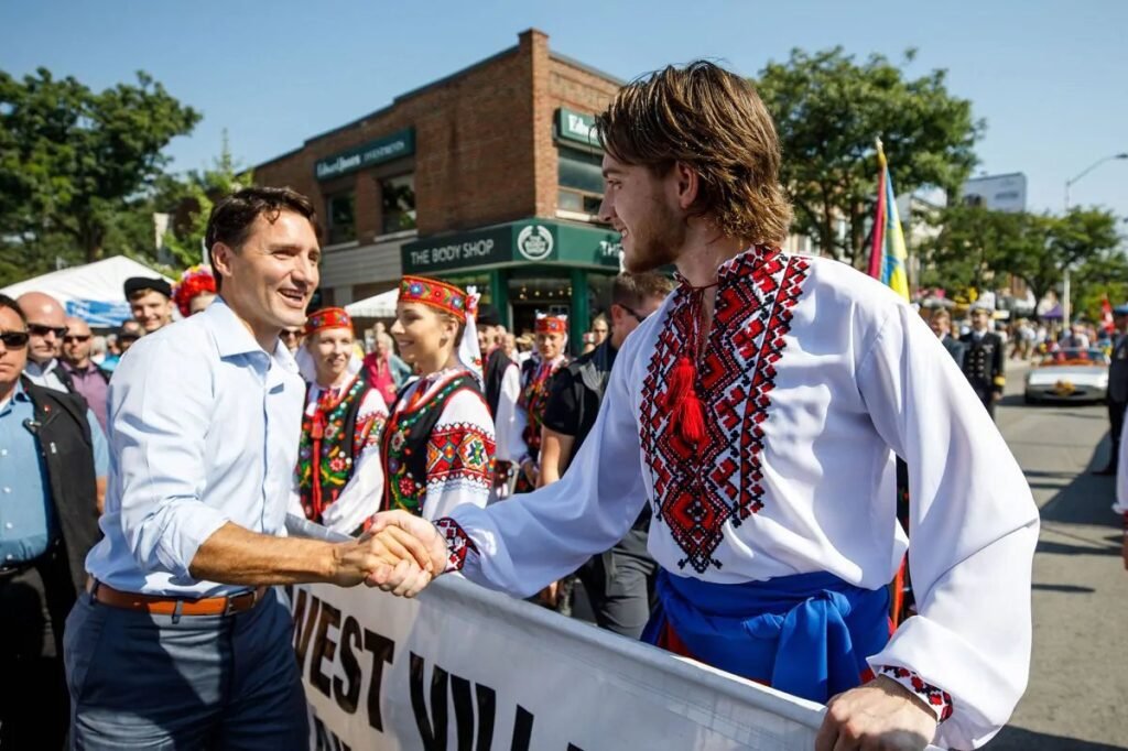 Прем'єр-міністр Канади Джастін Трюдо тисне руку юнакові в українській вишиванці під час параду в Торонто.