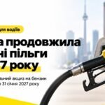 Заправний пістолет жовтого кольору в паливному баку білого автомобіля на фоні канадського прапора та панорами Торонто