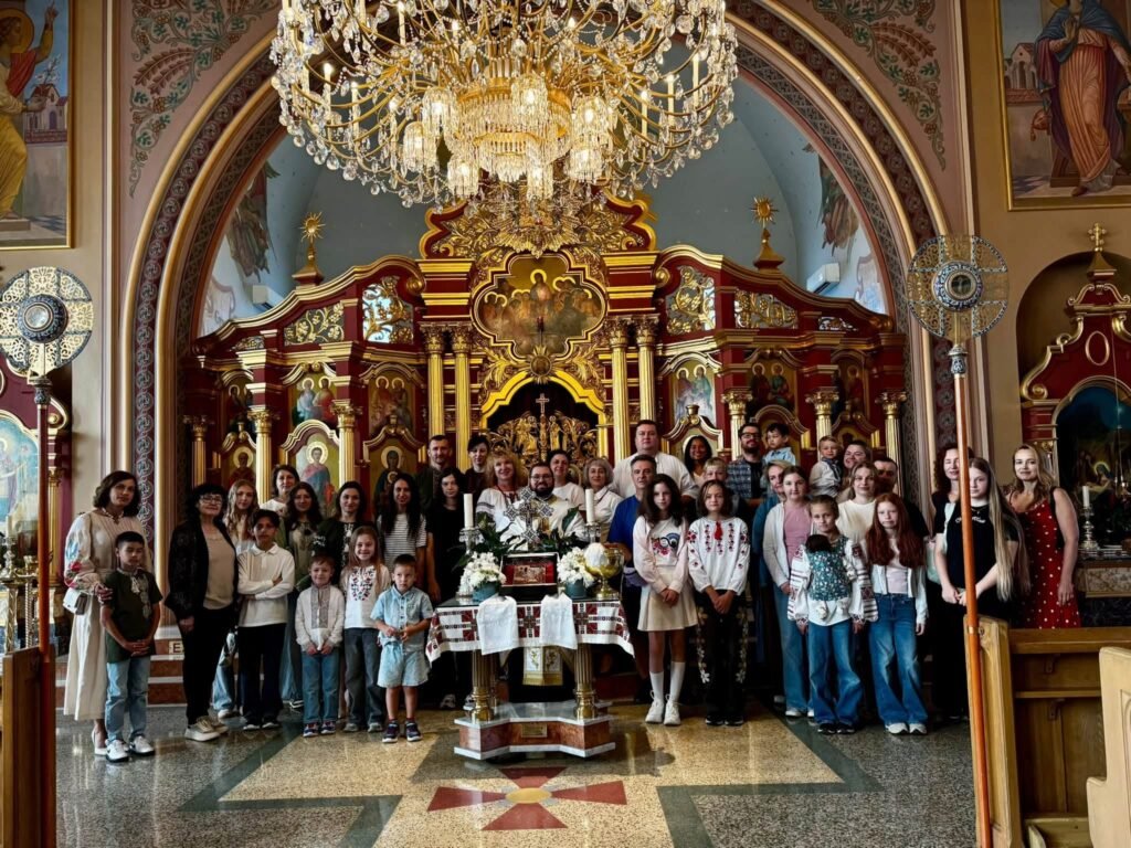 Групове фото дітей та дорослих у вишиванках в інтер'єрі собору перед золотим іконостасом